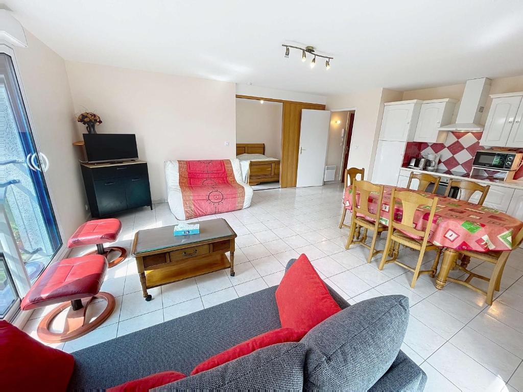 un salon avec un canapé et une table dans l'établissement Appartement avec parking à 250m de la plage, proche commerces - FR-1-361-120, à Jullouville
