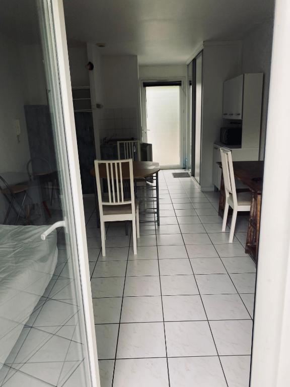 Il comprend une cuisine et une salle à manger avec des chaises et une table. dans l'établissement Appartement Cosy Pau avec Jardin, à Pau