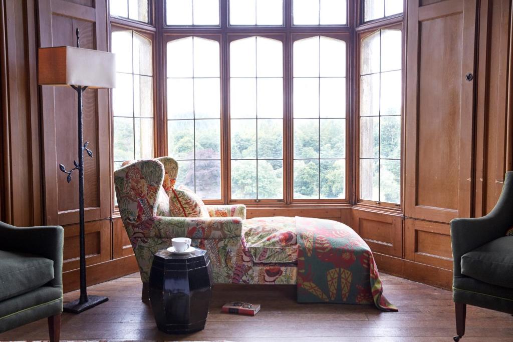 a woman sitting in a chair in a room with windows at Hotel Endsleigh in Milton Abbot