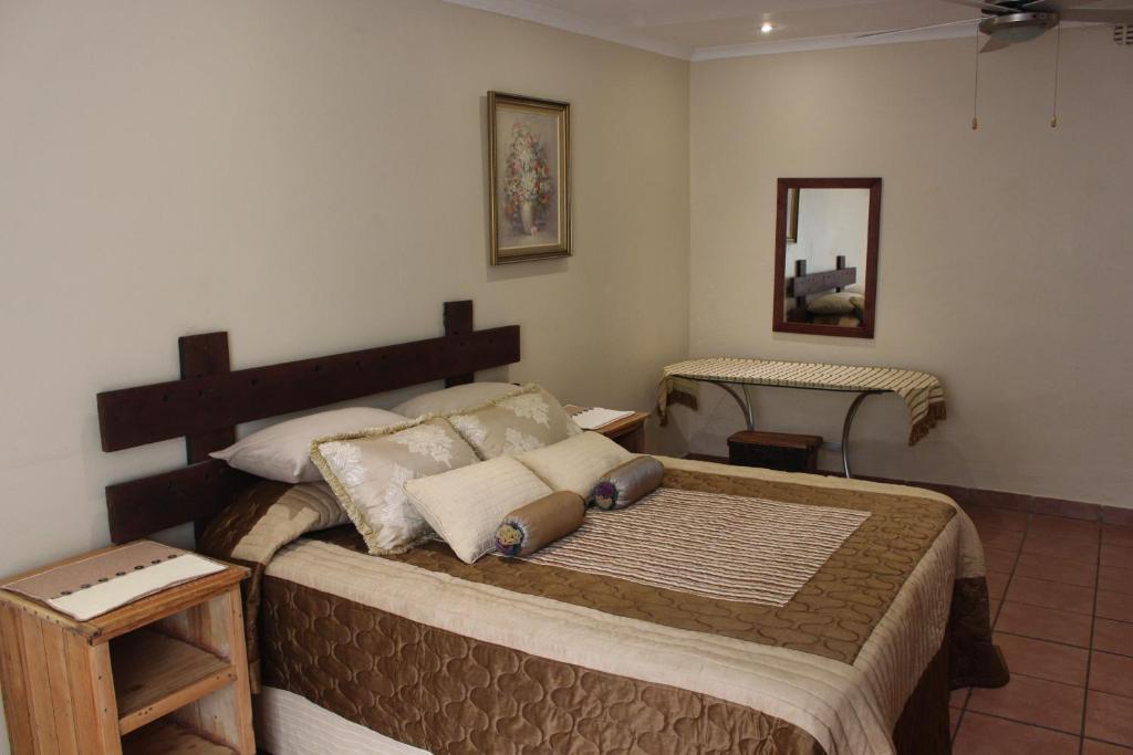 a bedroom with a large bed in a room at Charming Self Catering Apartment in Phalaborwa