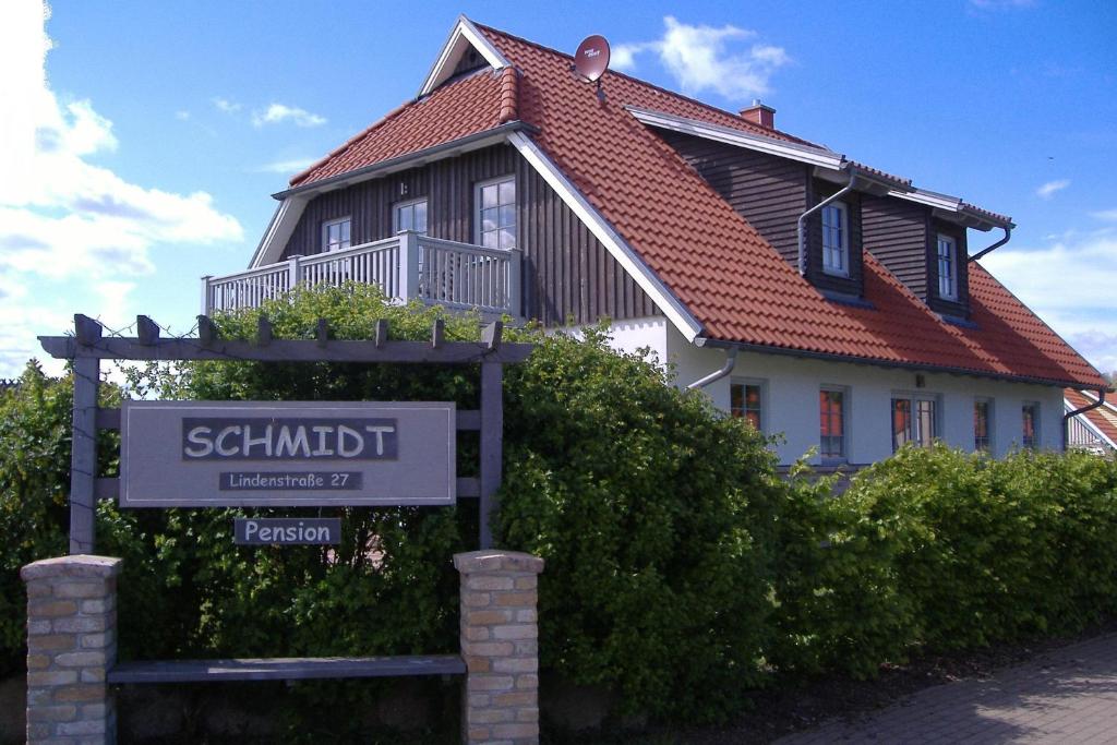 ein Haus mit einem Schild davor in der Unterkunft Schmidt's Pension Schwansee in Groß Schwansee