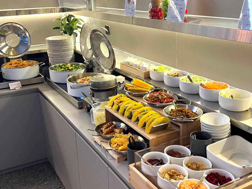a buffet line with many different dishes of food at Atour Light Hotel Guangzhou Panyu Hanxi Changlong-Free Midnight Snack&16 minutes drive to Conton Fair&Free Coffee Togo&Free Laundry and Drying services in Guangzhou