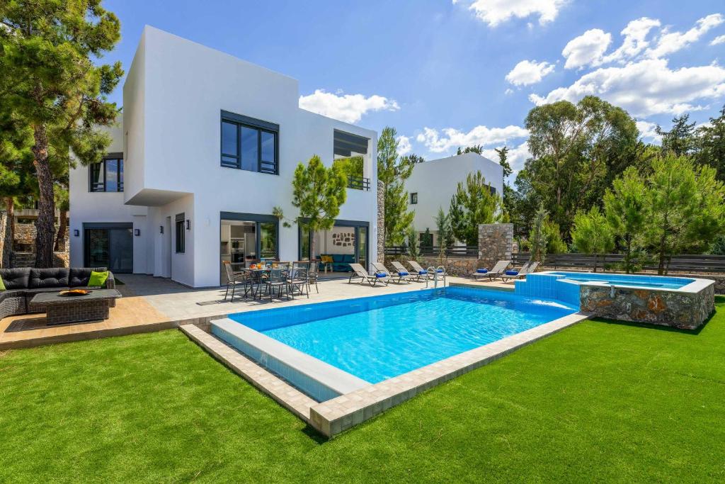 a swimming pool in the yard of a house at Villa Summer Dawn in Kiotari