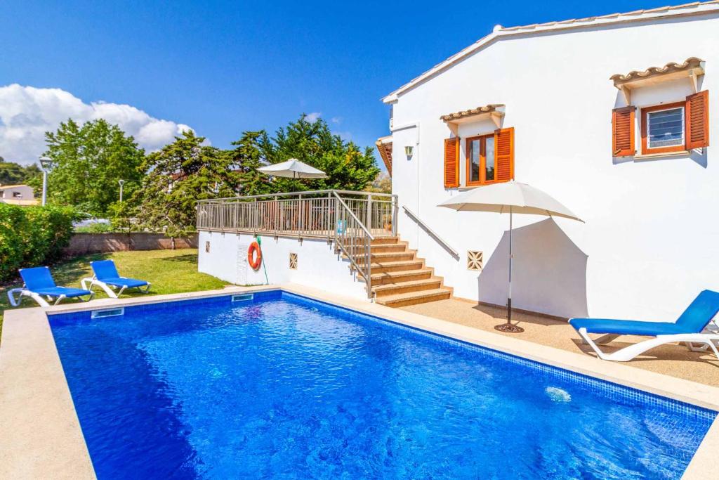 a villa with a swimming pool in front of a house at Villa Voltor Cinco in Pollença