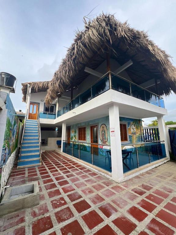 a building with a thatched roof with a patio at Cabaña Sol y Mar Coveñas in Coveñas