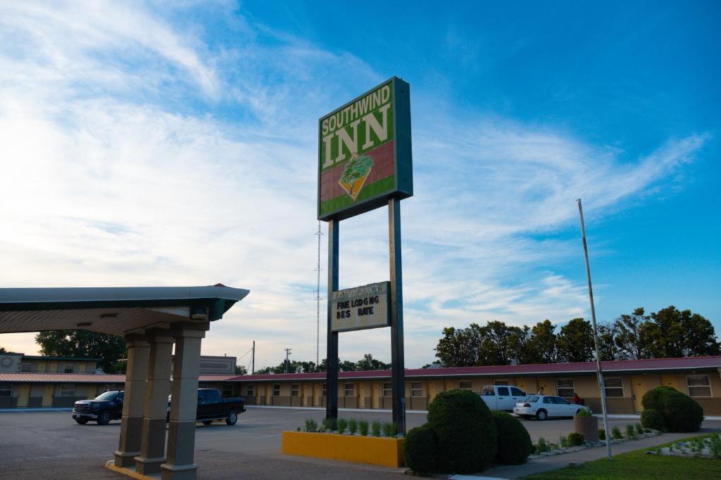 a sign for an inn in a parking lot at South Wind Inn in Liberal