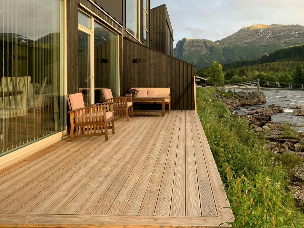 een houten terras met een tafel en stoelen op een huis bij Hytte Ved Heimsila I Hemsedal in Hemsedal