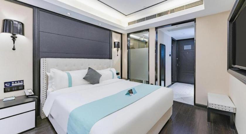 鄭州市にあるXana Hotelle Zhengzhou North Passenger Terminal North University Townの大きな白いベッドと窓のある寝室