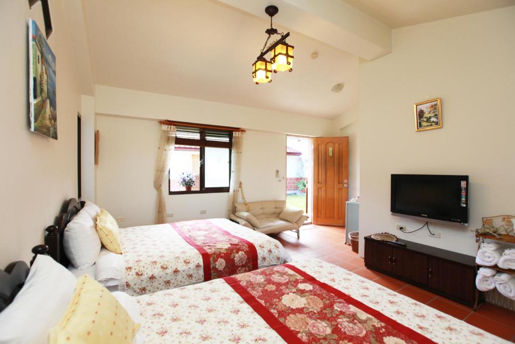 蘇澳鎮的住宿－閑居民宿，一间卧室配有两张床和一台平面电视