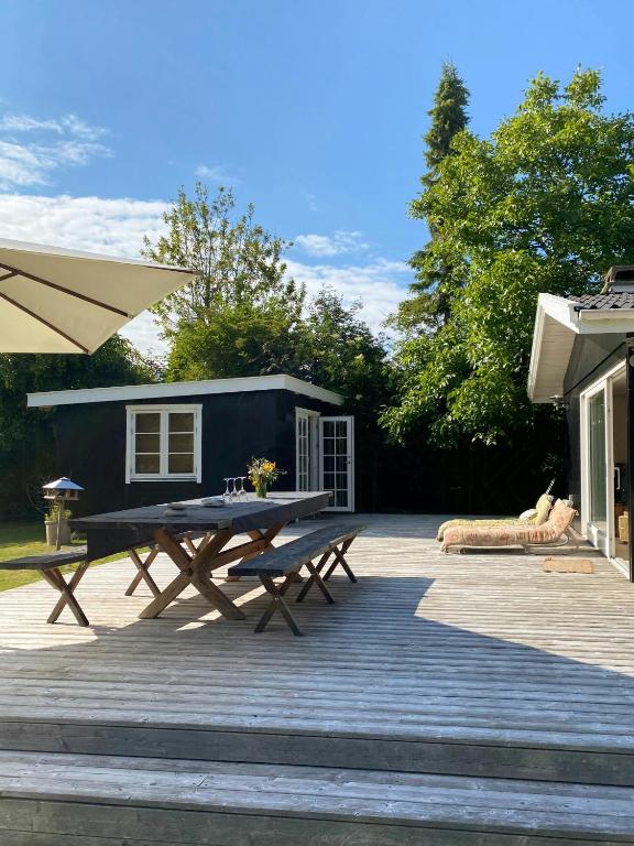un patio avec une table de pique-nique et une roulotte dans l'établissement Nordic Haven For Families At Guest Houses, à Vejby Strand