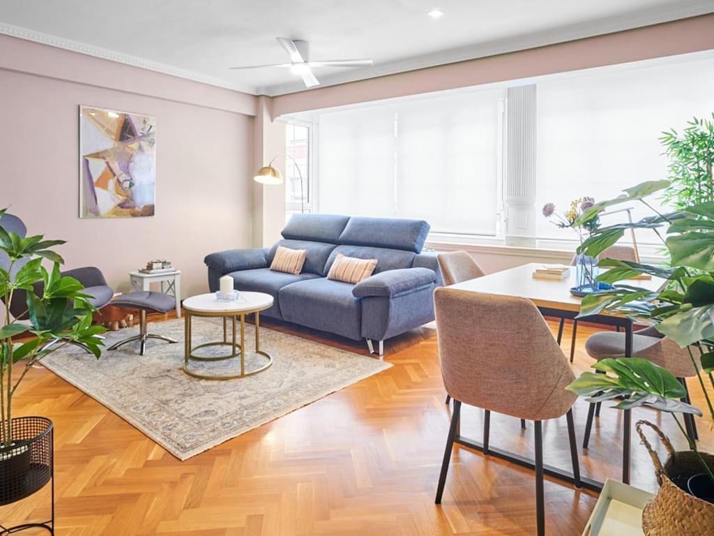 a living room with a blue couch and a table at Zorrilla - by Wehomes in Santander