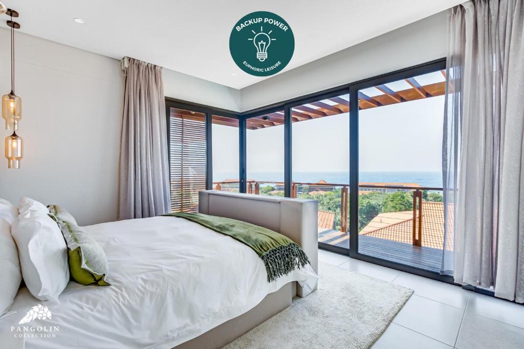 ein Schlafzimmer mit einem Bett und einem großen Fenster in der Unterkunft Oceans Edge 13, Zimbali Estate by Euphoric Leisure in Ballito
