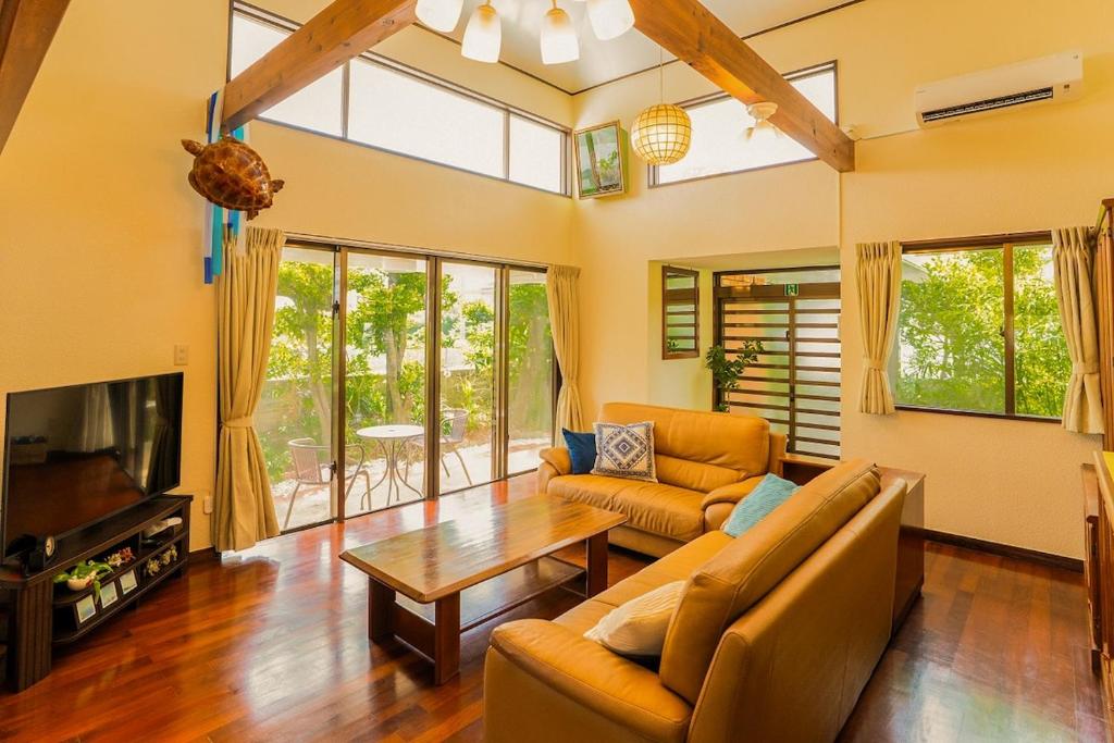 a living room with a couch and a table at Peace Branch in Yonabaru