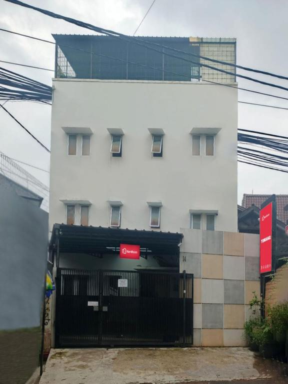 a white building with a black gate in front of it at NamRoom at Tomang in Jakarta