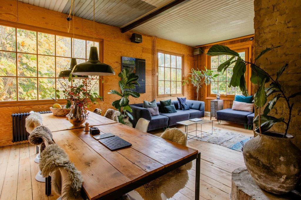 a living room with a wooden table and chairs at Restored Quarry House Near Nobel Laureate Home in Lönsboda