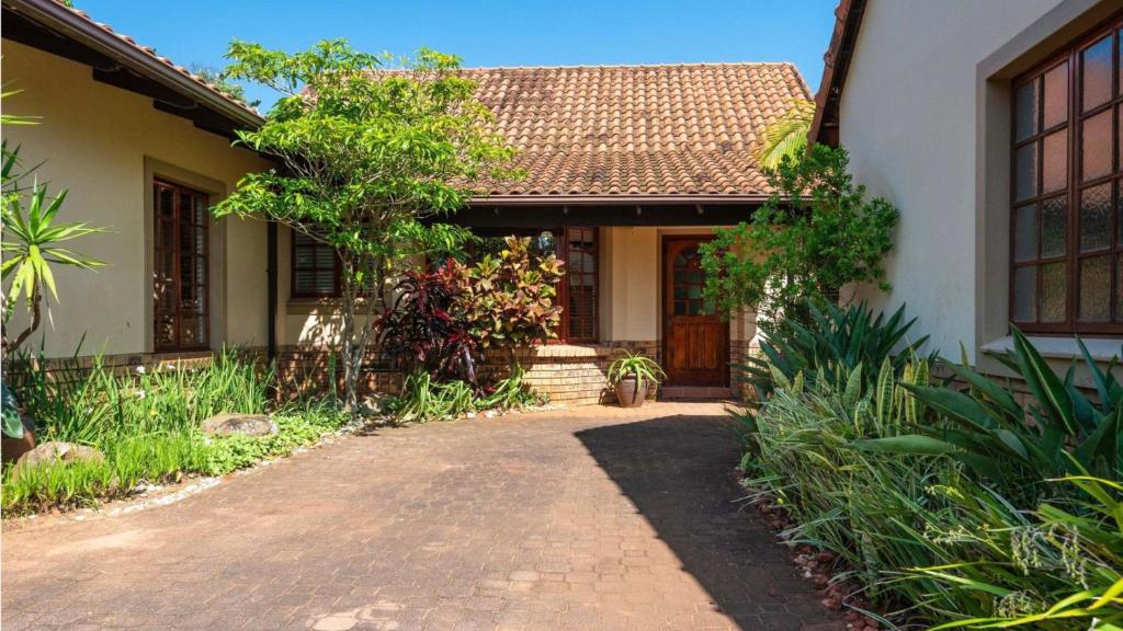 a house with a pathway leading to the front door at Fairways 5, Zimbali Estate by Euphoric Leisure in Ballito