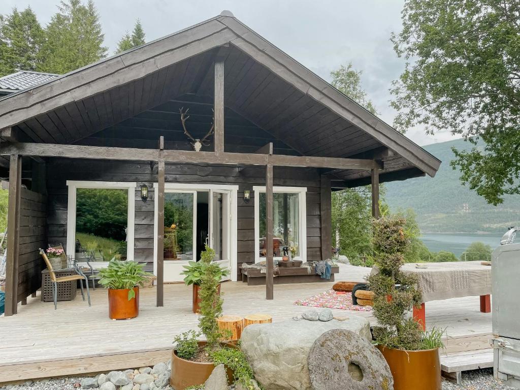 una casa con un grande terrazzo in legno con piante di Cozy Modern Cabin In West Norway With View a Davik