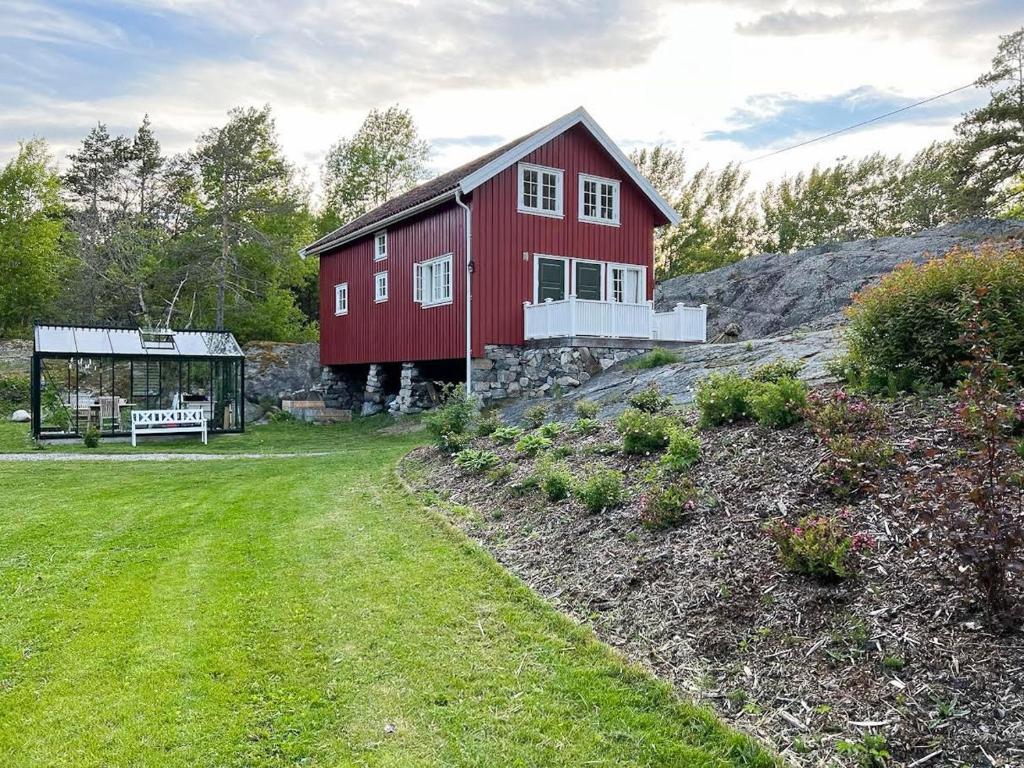 StabbestadにあるHistoric Farmhouse By The Archipelago Parkの緑の畑の上に座る赤納屋