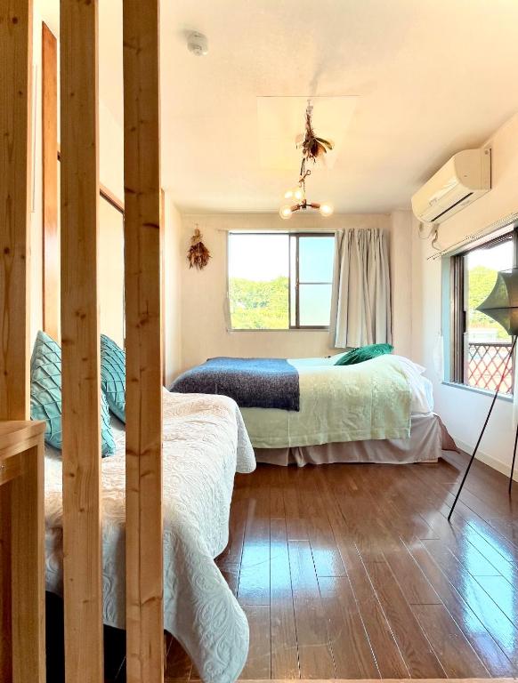 Un dormitorio con dos camas y una ventana. en 民泊宿 i s e s h i m a 伊勢内宮前203, en Ise