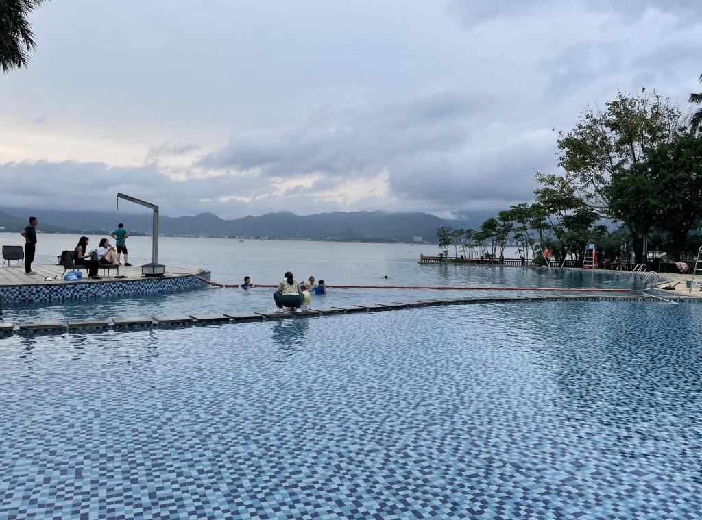 una grande piscina accanto a uno specchio d'acqua di Shenzhen Yusu Linting Seaview Inn Judiaosha Branch a Shenzhen