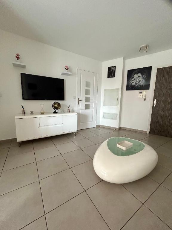 un salon avec une télévision et une table dans l'établissement Villa lumière, à Cannes