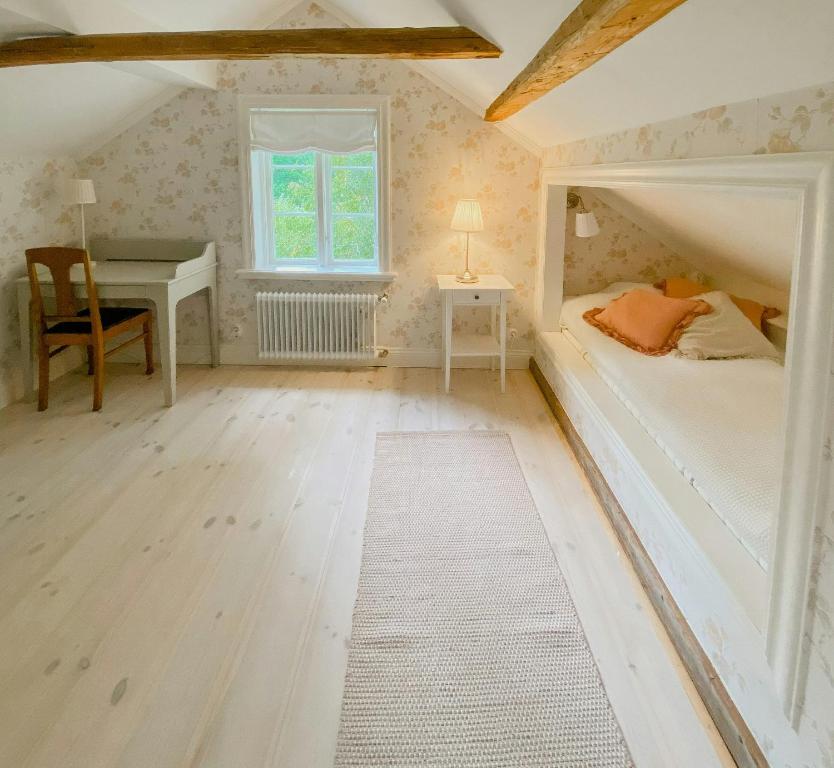 a bedroom with a bed and a desk and a table at Countryside Farm With Pool In Västergötland in Ljung