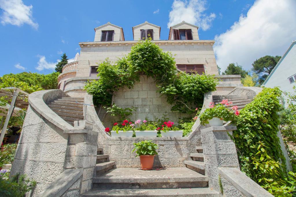 a building with flower pots on the stairs at Apartments Matijasevic in Korčula