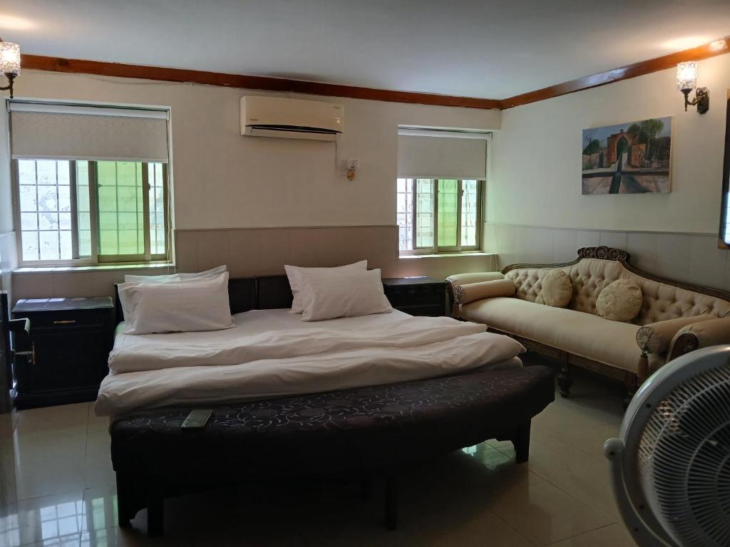 un dormitorio con una cama y un sofá en Room at khan house, en Islamabad