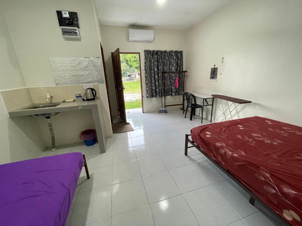 a bedroom with a bed and a sink and a table at Motel Santai Bandar Pekan in Pekan