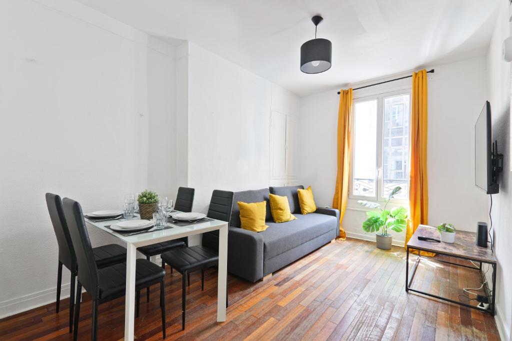 - un salon avec un canapé et une table avec des oreillers jaunes dans l'établissement Heart of Paris-1BR-4P-Tour Eiffel 8 -Free Netflix, à Paris
