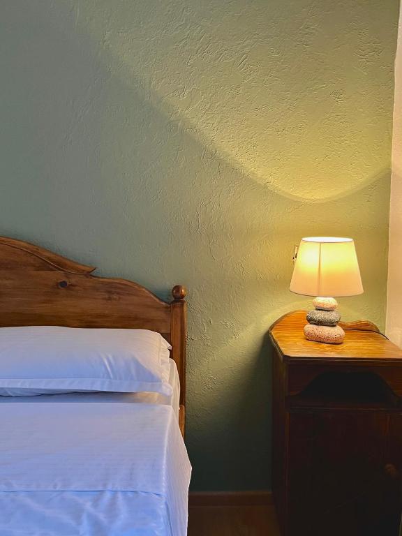 a bedroom with a bed and a lamp on a nightstand at Cozy-Corner Guesthouse in Mestia