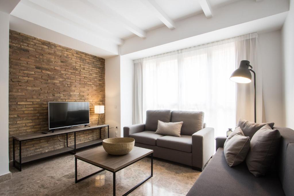 a living room with a couch and a tv at Flatsforyou Marina Playa in Valencia