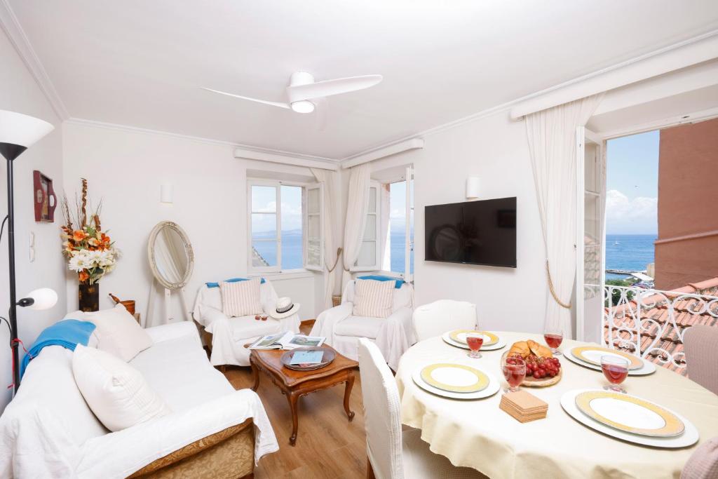 a living room with a white couch and a table at Ruby's Gem Corfu in Corfu