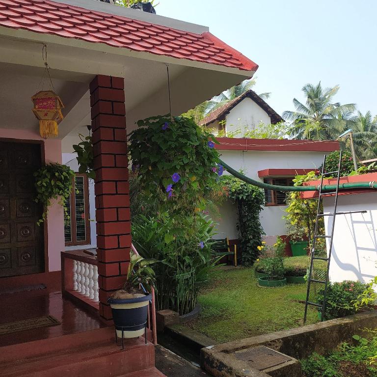 a house with a red roof and a porch at Airport to Comfort Homestay Near Mangalore International Airport in Mangalore