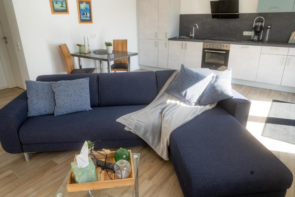 a blue couch in a living room with a table at Appartement am Hostertberg 1 in Simmerath