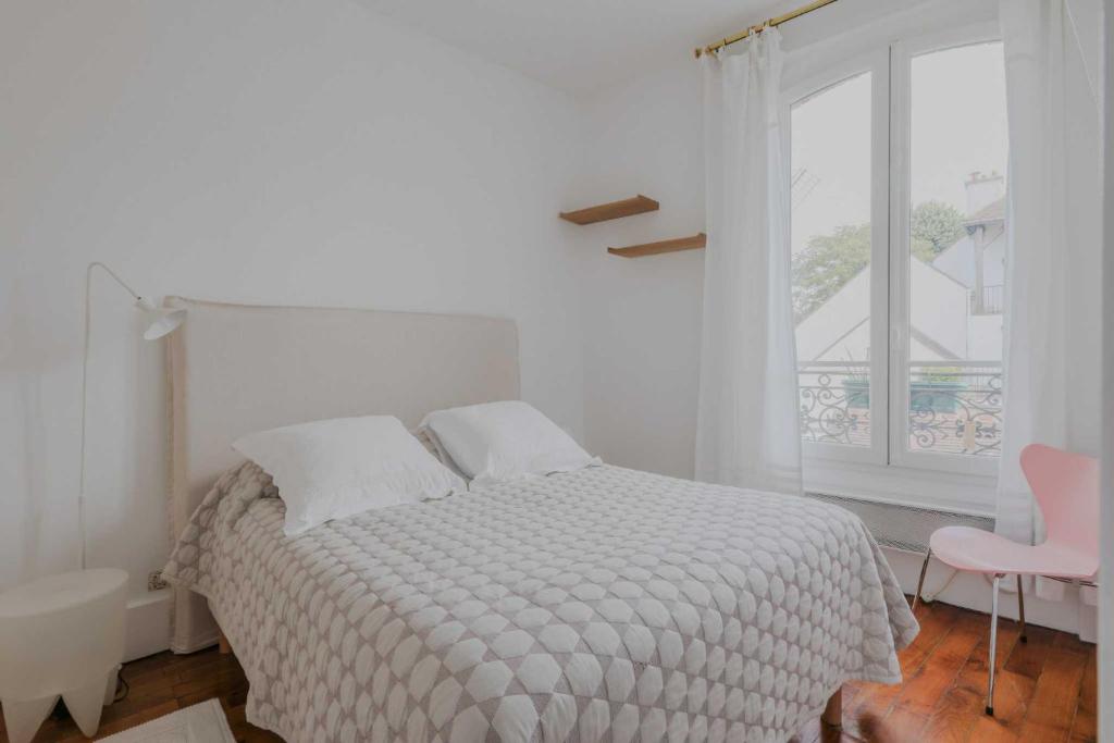 une chambre blanche avec un lit et une fenêtre dans l'établissement Magnificent apartment- 2BR 4P- Near Sacré-Cœur, à Paris