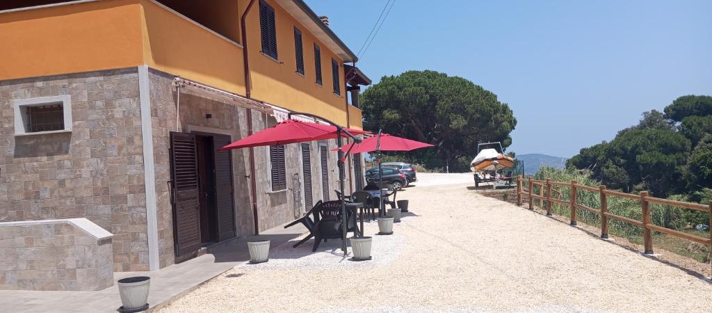 un edificio con mesas y sombrillas en una calle en Casale Gabriella Alloggio ergonomico e spazioso, en Capoliveri