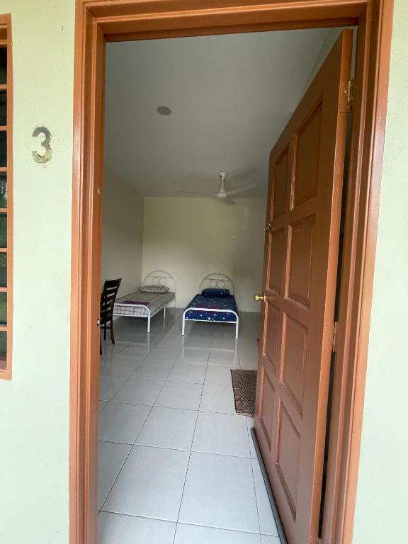 an open door to a room with two beds at Bilik 3 Katil Single Aircond Pekan in Pekan