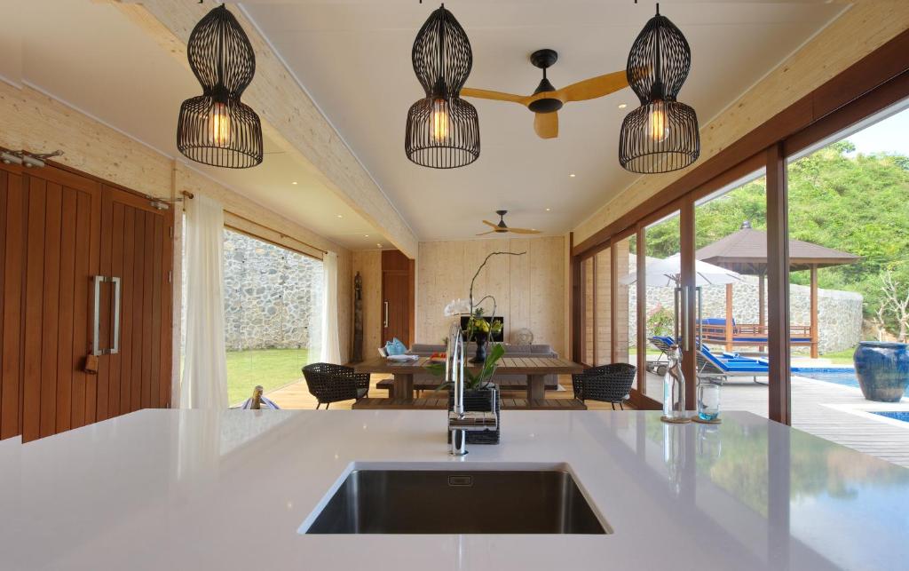 a kitchen with a sink and pendant lights at Selong Selo Resort and Residences in Selong Belanak