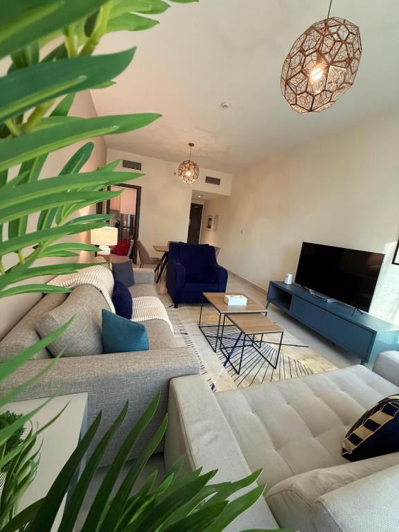a living room with a couch and a tv at Stunning Park View 1Bhk 4pax in Dubai