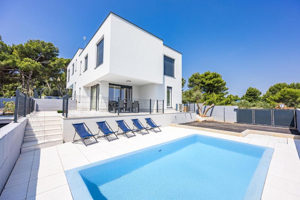a villa with a swimming pool and a house at Peninsula Villas in Premantura
