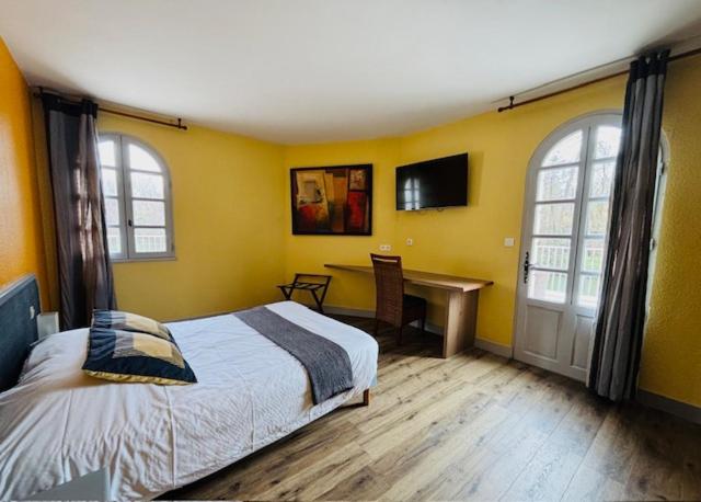 une chambre avec un lit et un bureau dans l'établissement Le Moulin Neuf, à Le Gond-Pontouvre