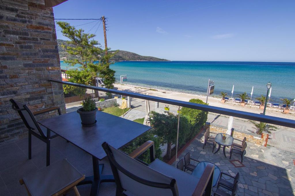 balcone con tavolo, sedie e spiaggia di Seabird Apartments a Skala Potamias