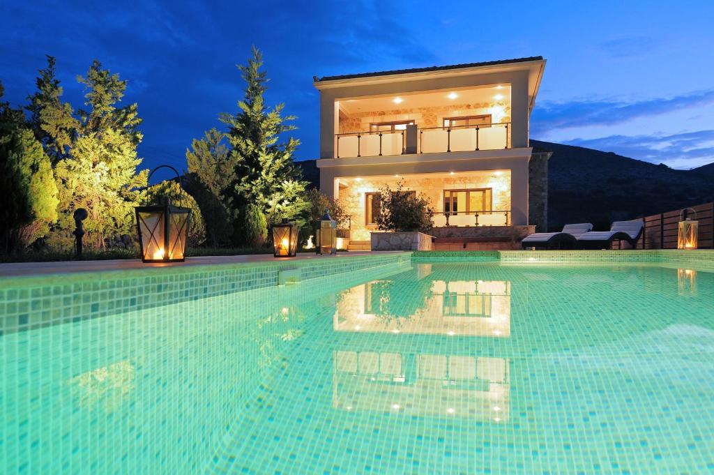 a large swimming pool in front of a house at Villa Unique in Divarata