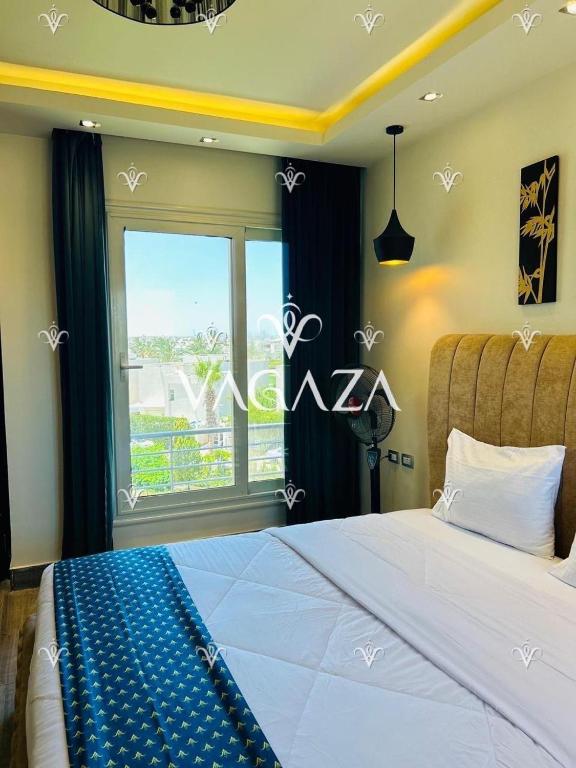 a bedroom with a large bed and a large window at For Rent Luxurious 3-Bedroom Chalet at Hacienda Bay, North Coast, Egypt in El Alamein