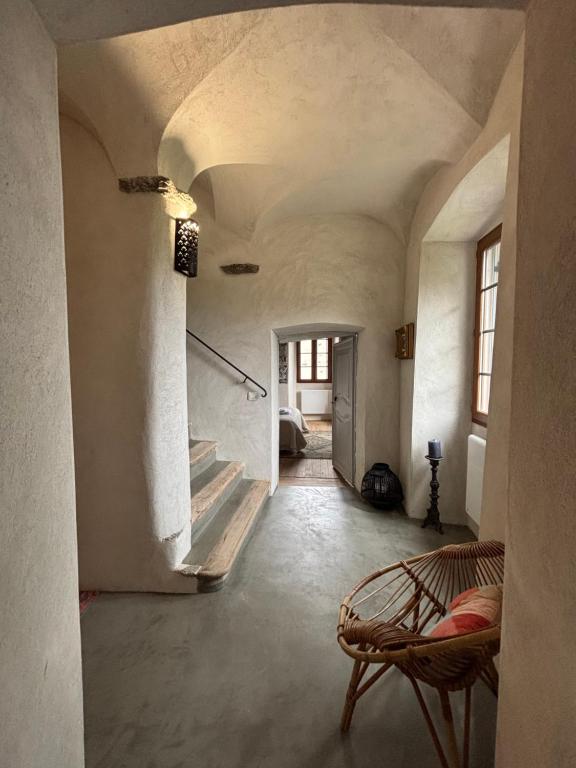 Cette chambre dispose d'un escalier et d'une chaise. dans l'établissement Maison de Caractère au coeur du village, à Castifao