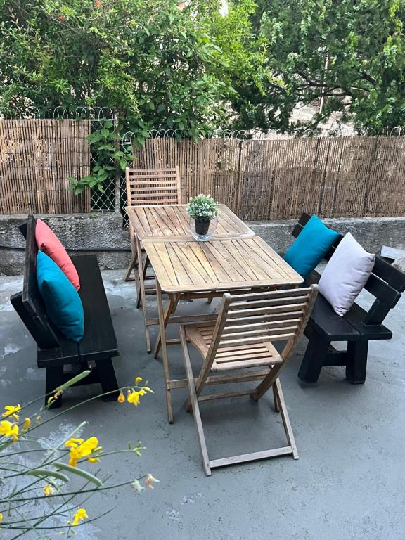 une table en bois et deux chaises avec des coussins dans l'établissement Beach, à Saint-Mandrier-sur-Mer