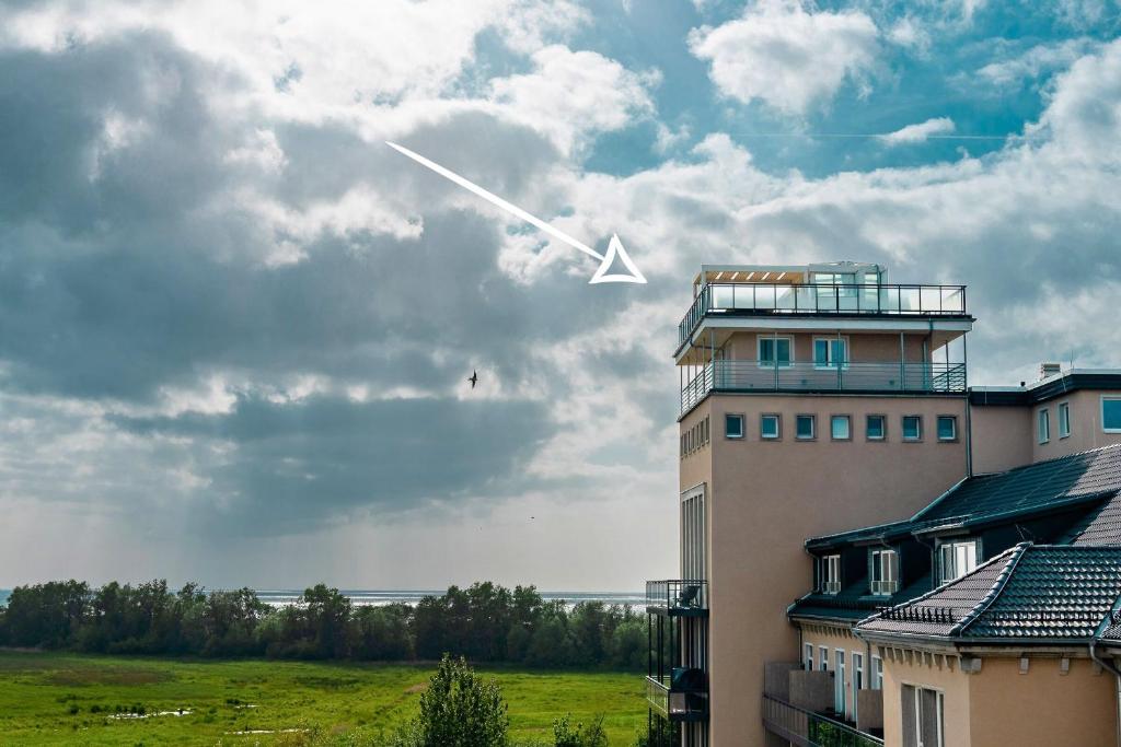 a plane is flying in the sky above a building at Panoramasuite The Turm - Penthouse in Wustrow