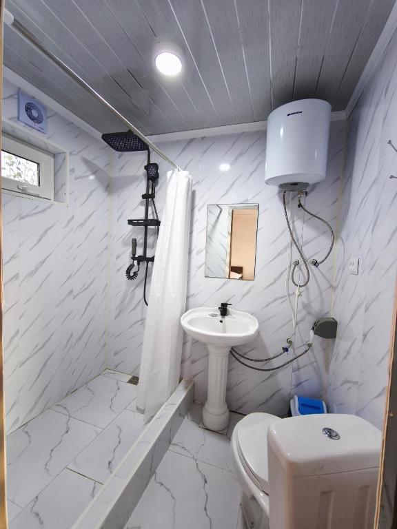 a white bathroom with a sink and a toilet at Meymandos in Tossor