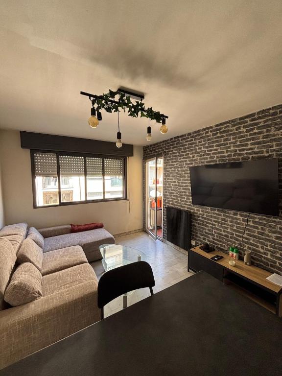 un salon avec un canapé et une télévision à écran plat dans l'établissement Charmant 2 pièce à 2min de la mer, à Nice